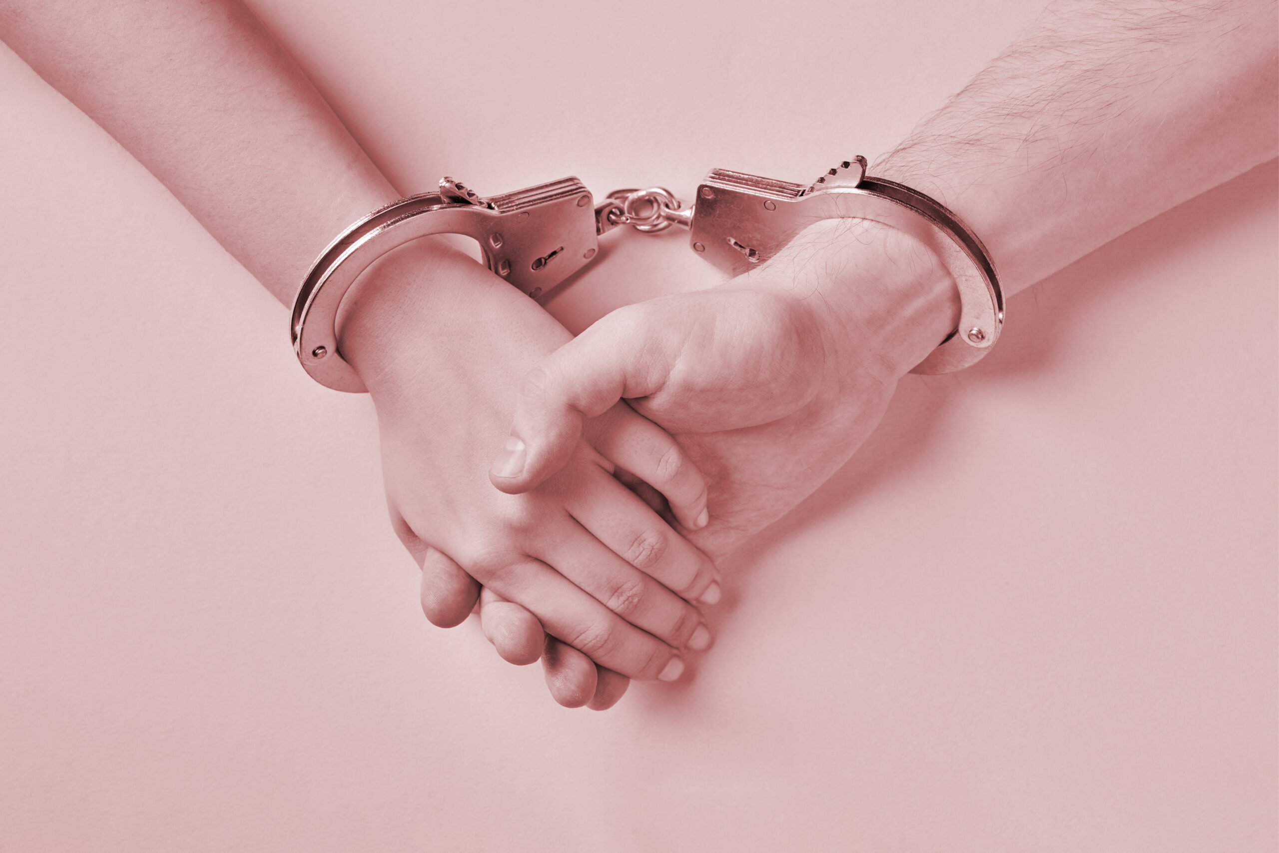 Male and female hands in handcuffs. Love forever.