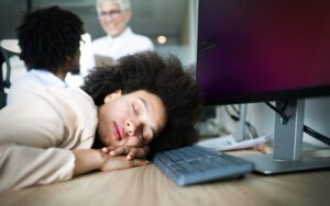 Overworked and tired businesswoman sleeping at work in her office