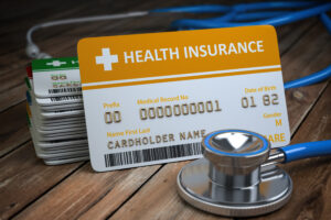 Health care medical Insurance card and stethoscope as a symbol of medicine on the wood background. 3d illustration
