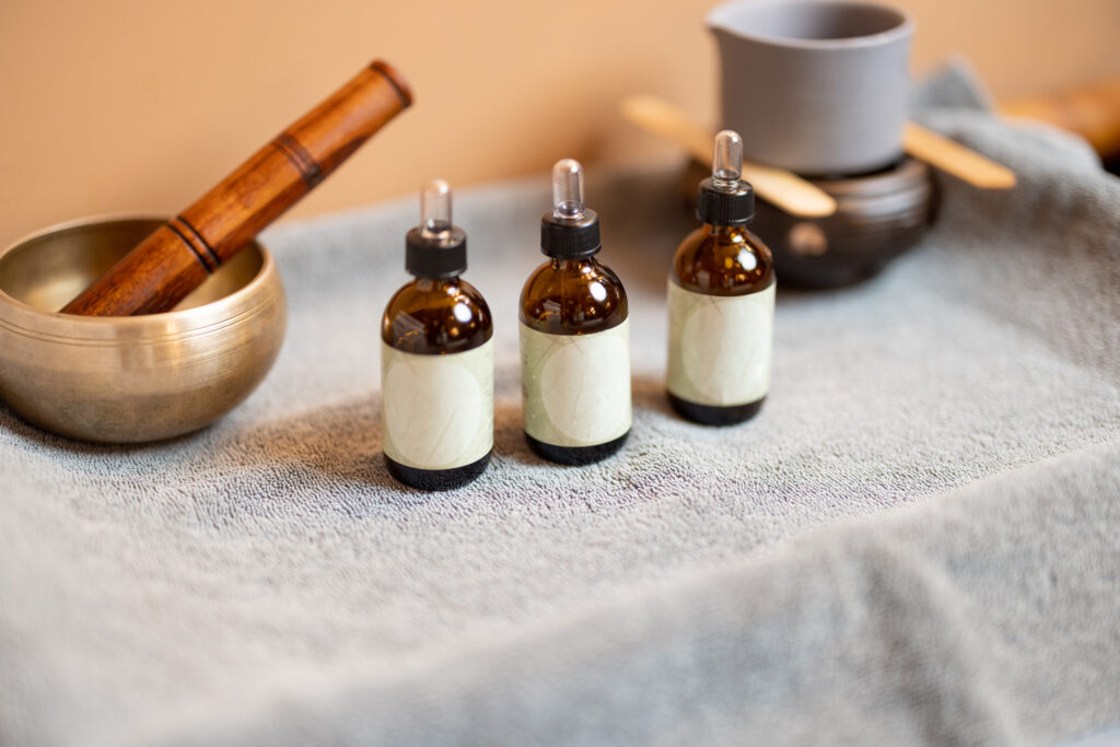 Essential oil for massage in jars and other props for massage on a towel