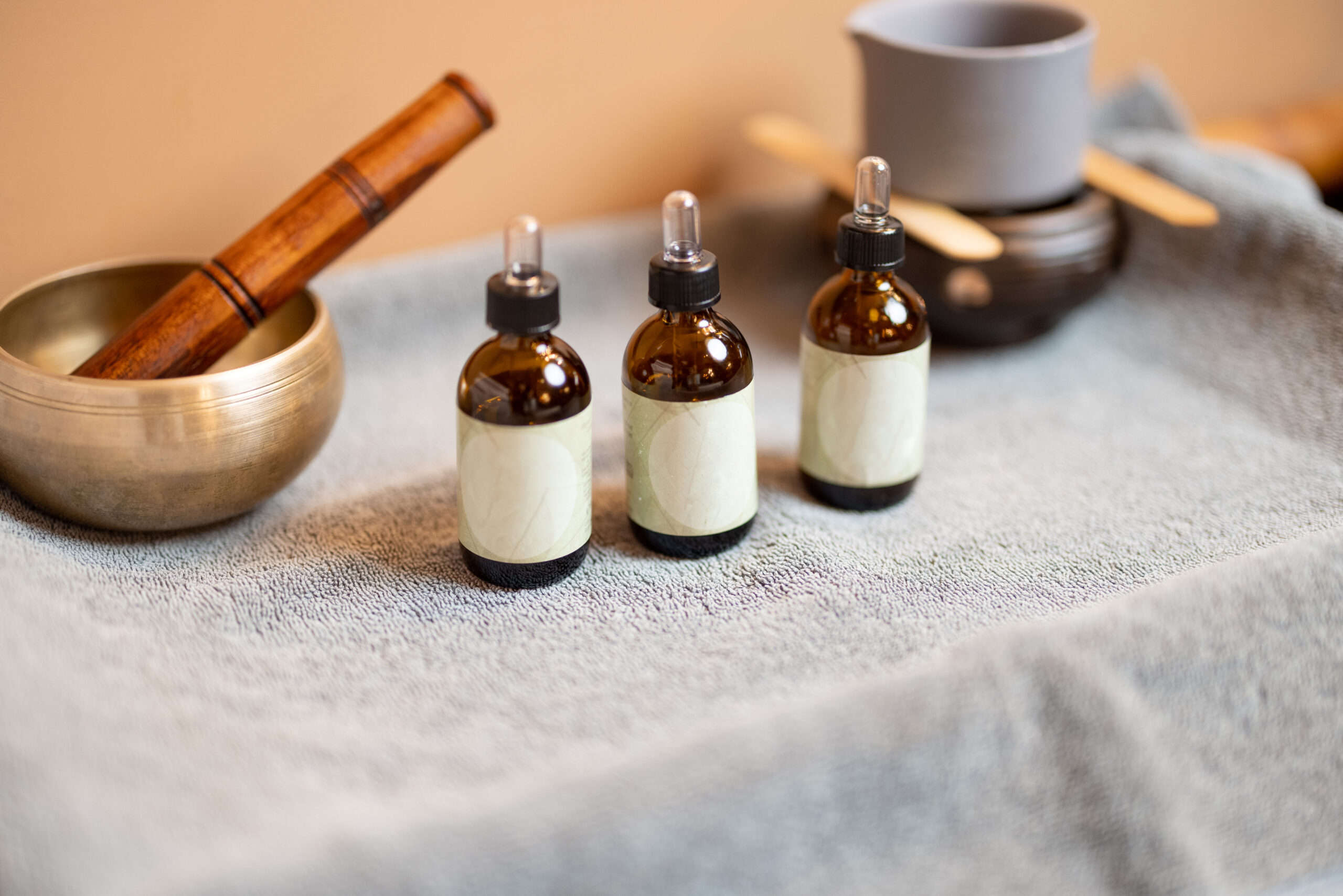 Essential oil for massage in jars and other props for massage on a towel