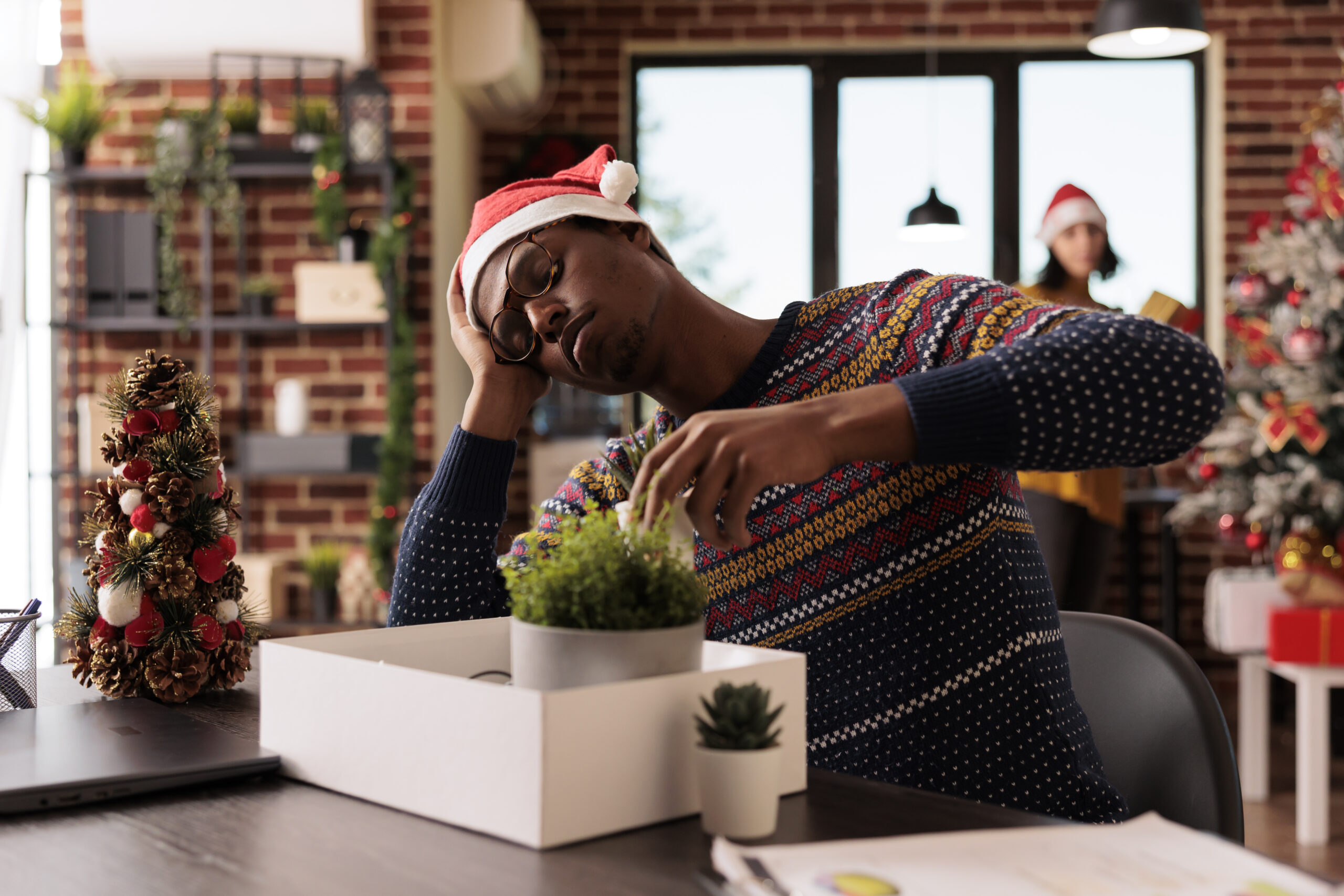 Sad depressed african american man experiencing job failure dismissed from work during holiday season. Unhappy worker packing office belongings after getting fired on xmas eve