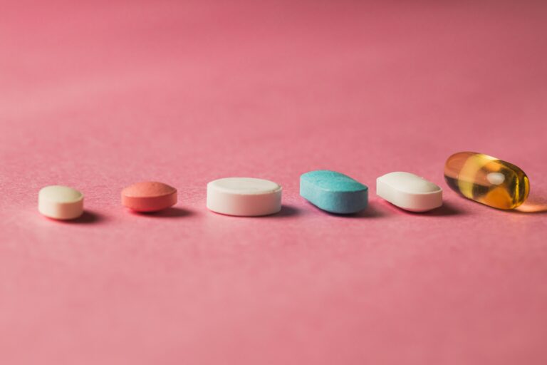 A closeup of pills arranged on a pink surface