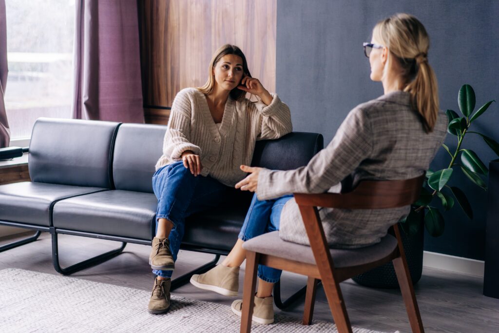 woman in individual therapy with her therapist sitting on a leather couch
