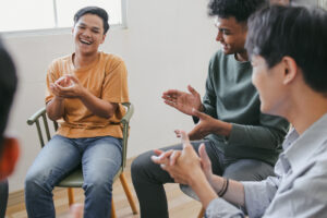 Group Of Diverse People Applauding To Themselves At Therapy Session In Rehab