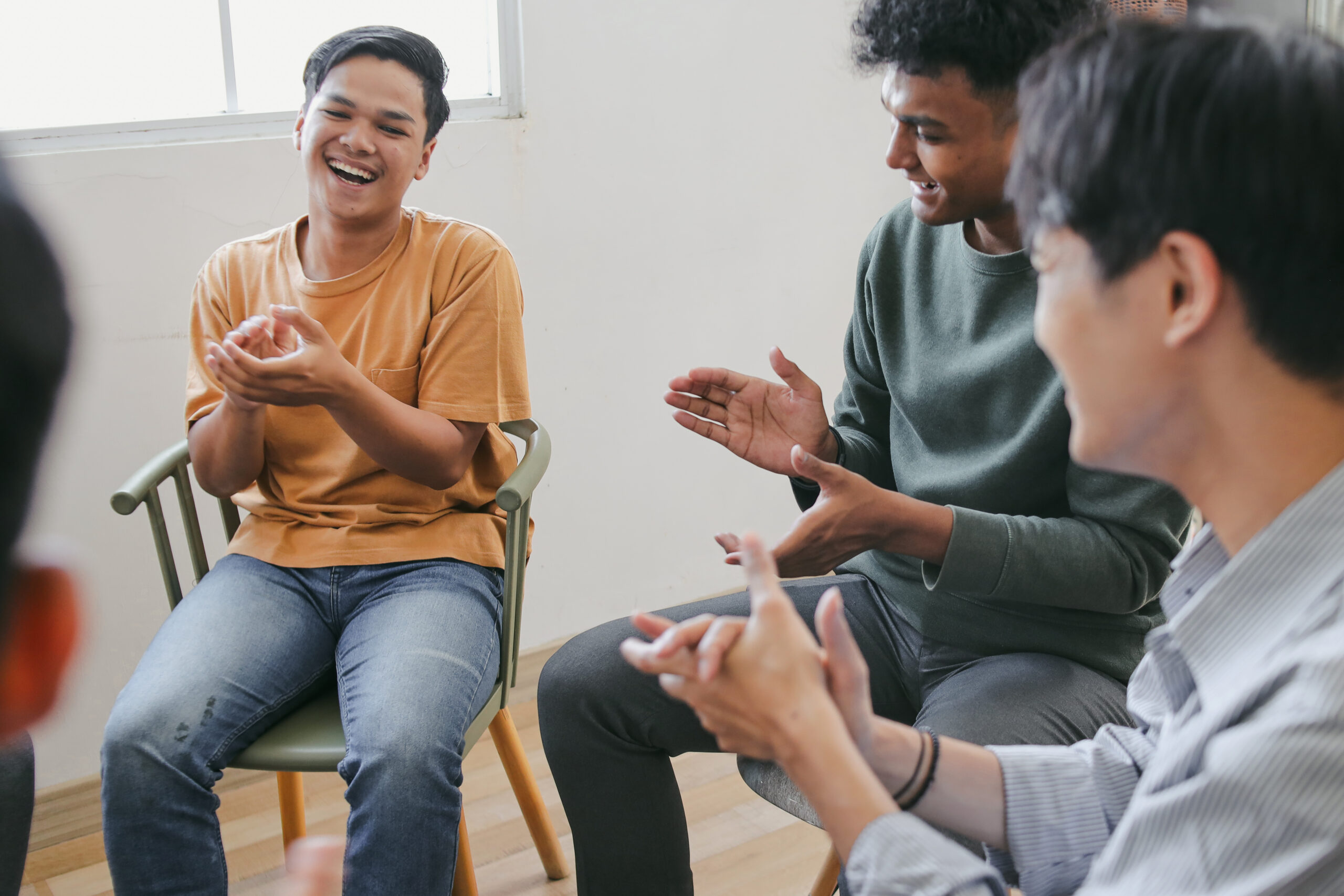 Group Of Diverse People Applauding To Themselves At Therapy Session In Rehab