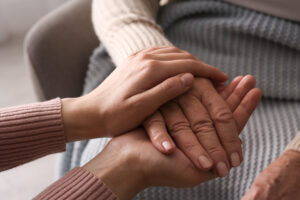 therapist holding the hand of their patient in a comforting way