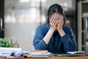Stressed business woman working from home on laptop looking worried and tired from hard work.