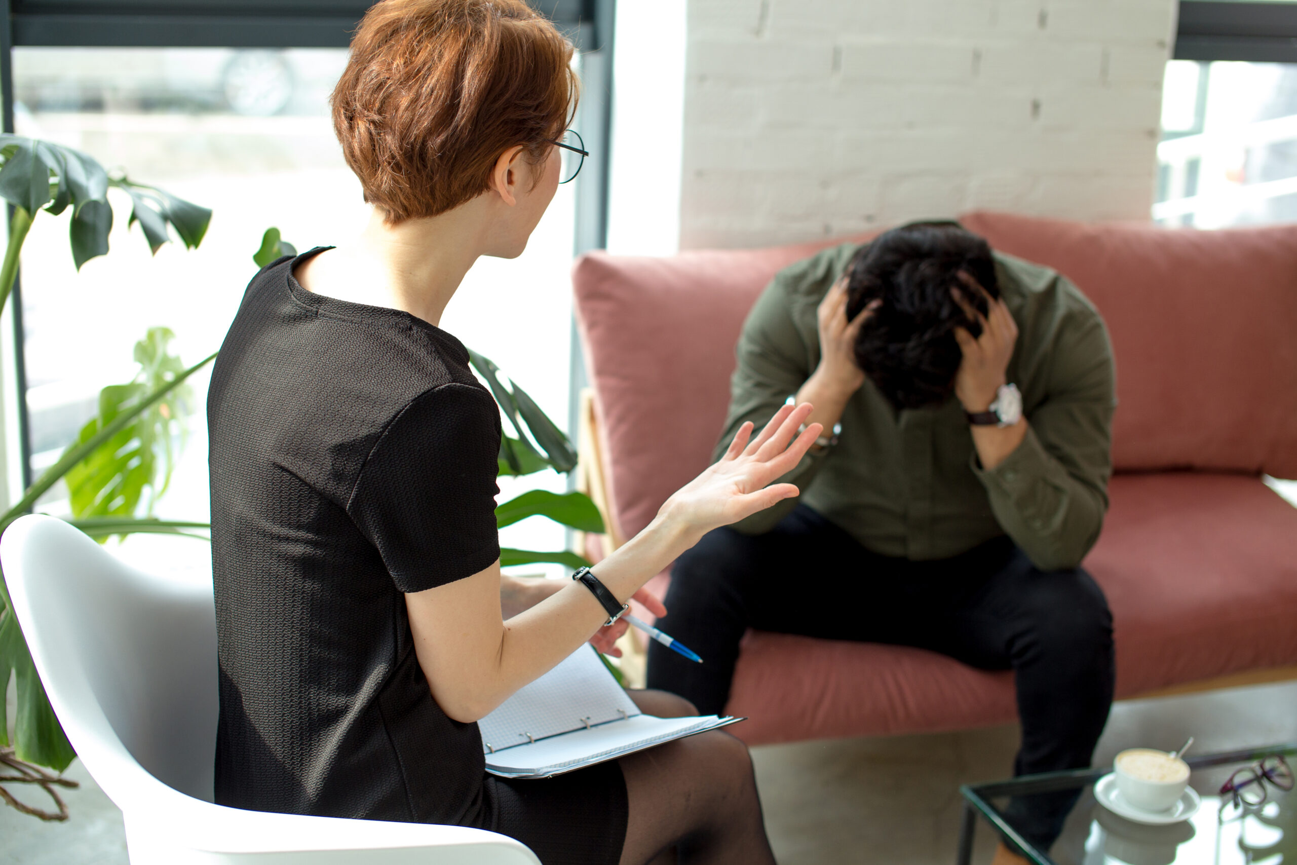 Young female psychologist working with indian man in modern office