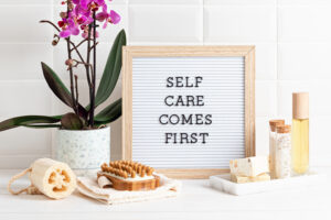 Bathroom styling and organization. Letter board with text Self care comes first. Organic lifestyle and skin care products.