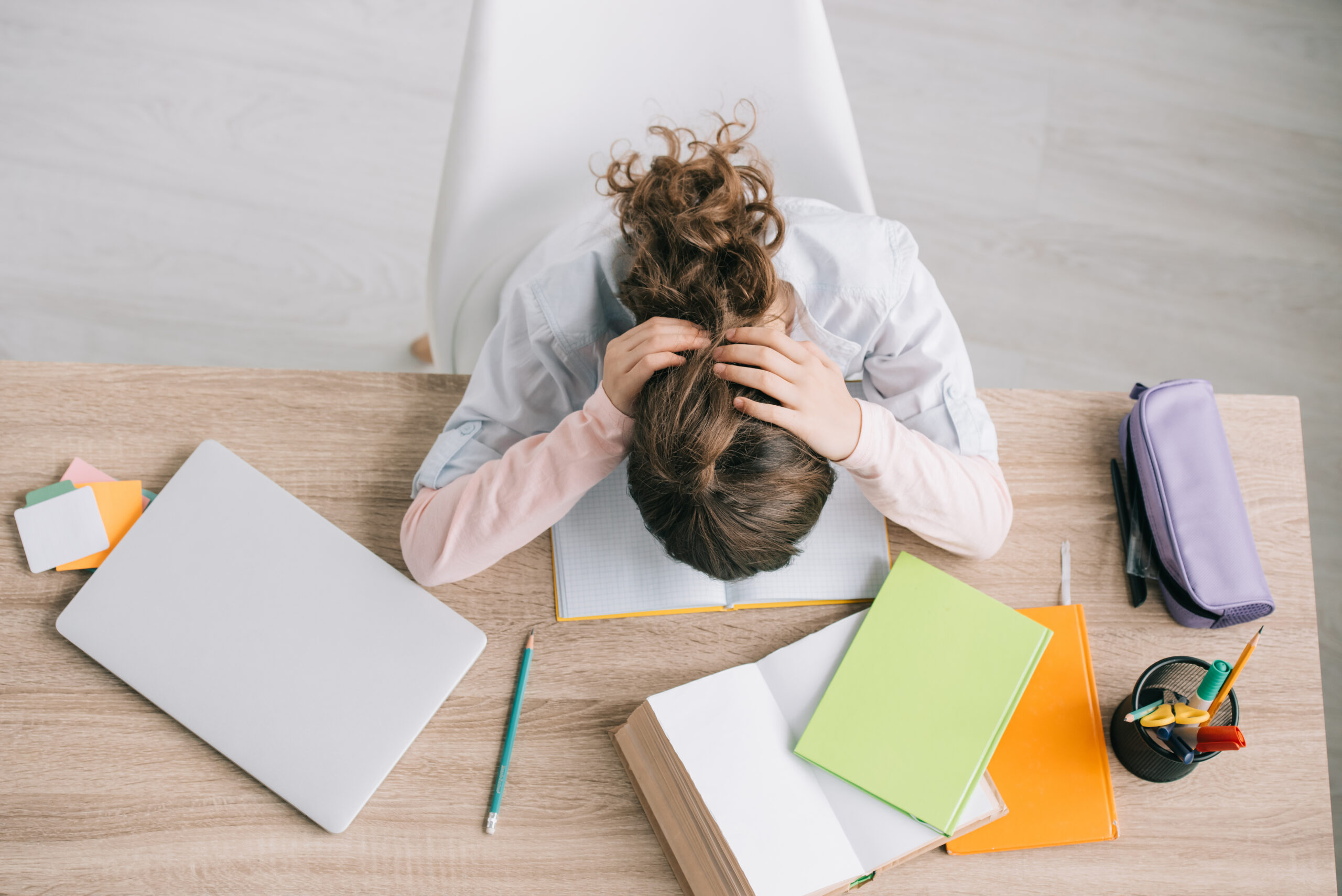 view of a young girl stressed while working on her school assignment