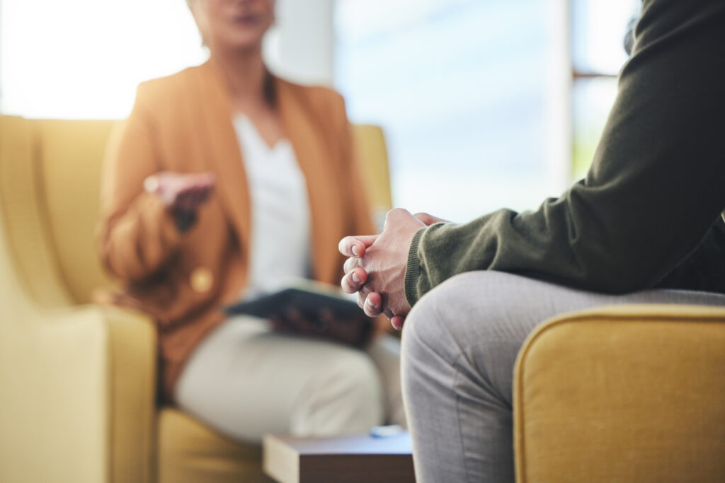 Man, hands and listening for therapy, sofa or advice from woman for mental health, psychology or ca.