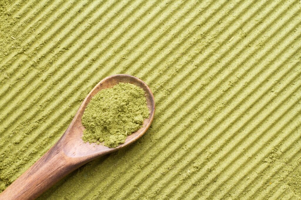 kratom powder with a wooden spoon